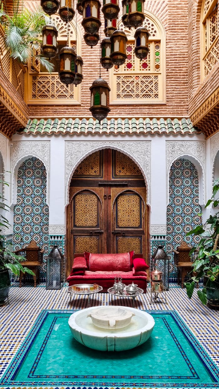 A propos 2 Stunning Moroccan riad courtyard with intricate tilework and central fountain.
